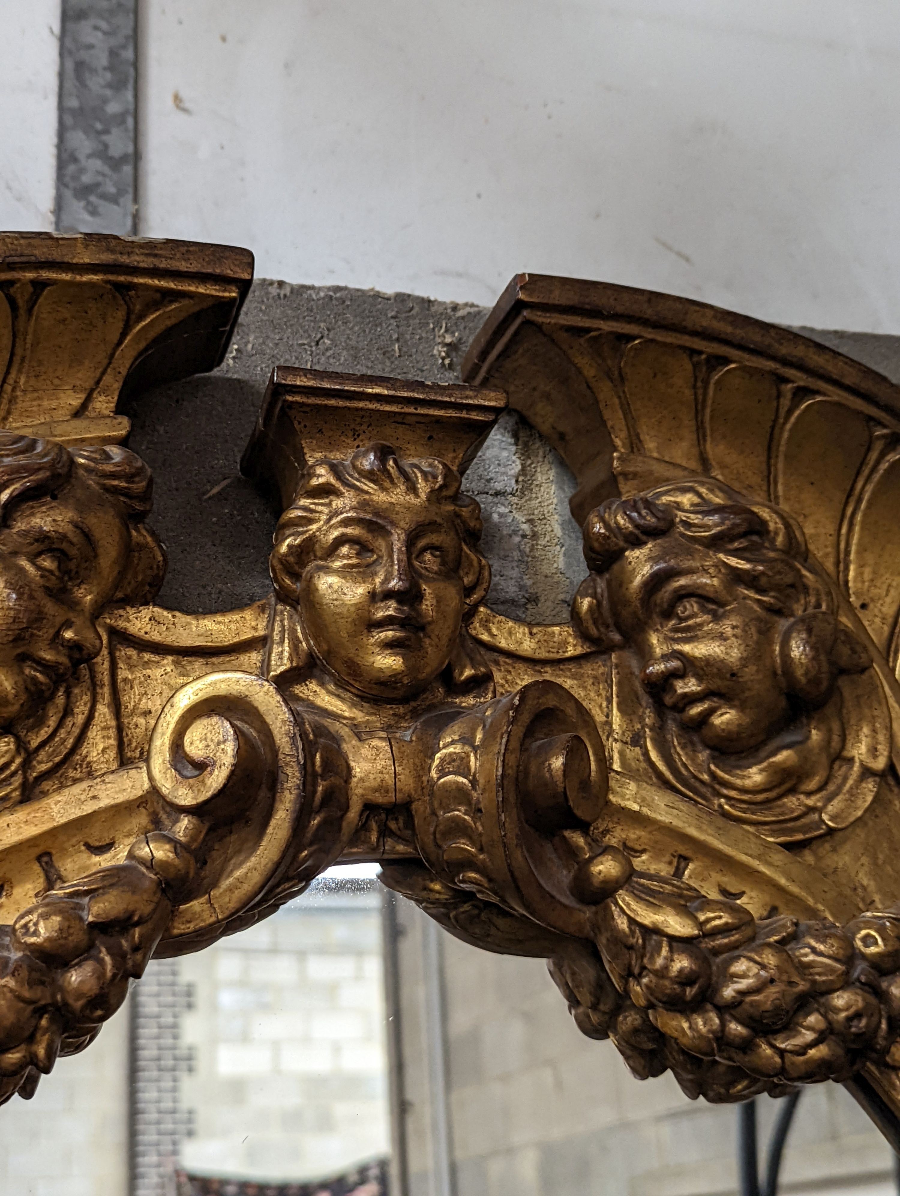 A Victorian carved giltwood oval wall mirror decorated with cherubs and C scrolls., width 74cm, height 110cm